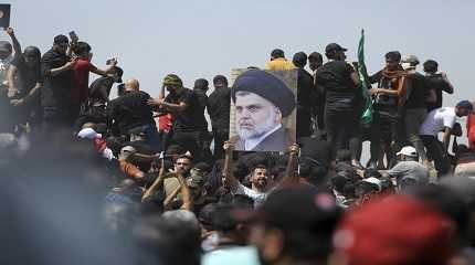 protester holds a poster depicting Shiite cleric Muqtada al Sadr