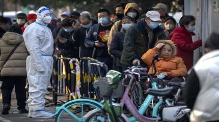 People wearing face masks wait for COVID-19 tests