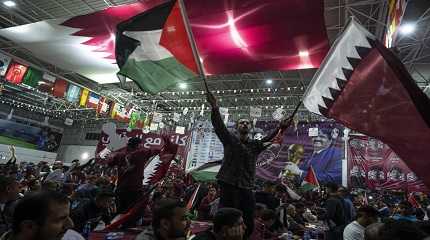 fans wave Qatari and Palestinian flags