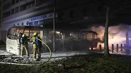 Firefighters extinguish a coach that had been set on fire