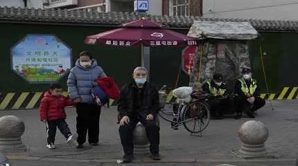 Residents wait to cross a road