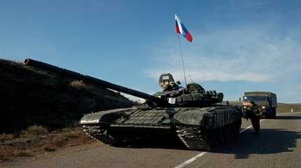 Russian peacekeeping troops stands next to a tank near the border