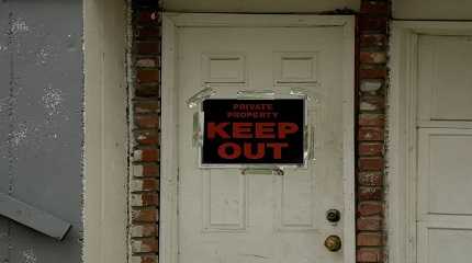 keep out sign is posted on a home