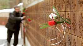 A man puts flowers into a wall 