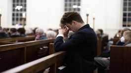 A person prays at a service at St. Paul's Memorial Church