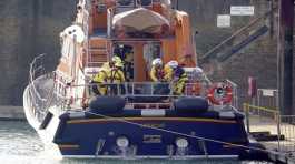 Members of the Dover lifeboat place a body bag on a stretcher