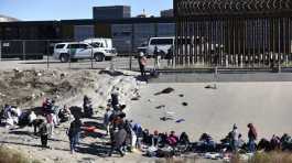 Migrants wait to cross the U.S. Mexico border