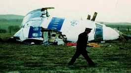 police officer walks by the nose of Pan Am flight 103