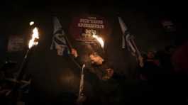 Israeli demonstrators hold torches during a protest