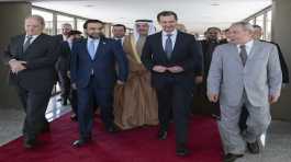 Bashar Assad walks with a delegation Arab parliaments