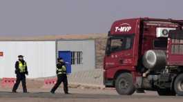 Police officers talk to a truck driver