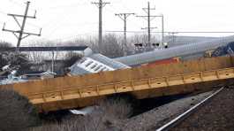 Multiple cars of a train lie toppled