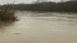 red SUV is submerged in floodwater