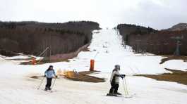 Skiers pass on an artificial snow slope