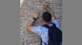 A tourist carves on the wall of the Colosseum in Italy 