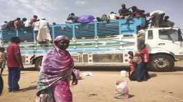 People board a truck as they leave Khartoum