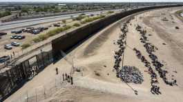 Migrants form lines outside the border