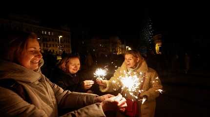 Women hold Christmas tree during a celebration