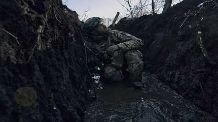 Ukrainian soldier takes cover in a trench