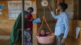 A child is weighed at a camp