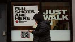 A man walks past an urgent care facility offering flu shots