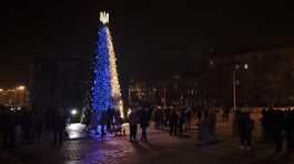 People gather around a Christmas tree