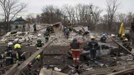 workers remove debris of a house destroyed