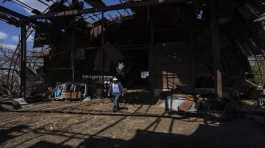 Ukrainian farmer Oleh Uskhalo walks inside a destroyed warehouse