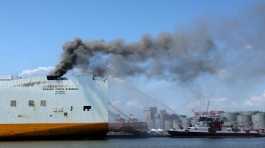 fire boat sprays water on a cargo ship