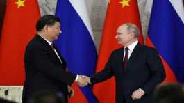 Vladimir Putin shakes hands with Xi Jinping